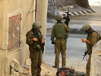 Soldados israelíes, junto al cadáver de uno de los dos palestinos. / Foto: AFP | Vídeo: Reuters