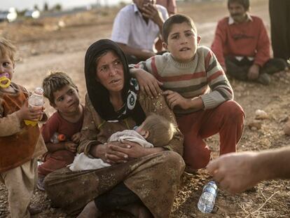 Una familia espera a cruzar la frontera con Turquía. / AFP | VÍDEO: REUTERS-LIVE!