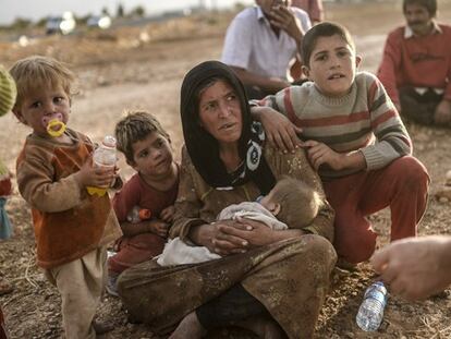 Una familia espera a cruzar la frontera con Turquía. / AFP | VÍDEO: REUTERS-LIVE!