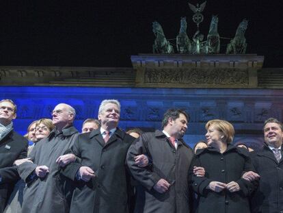 La canciller Angela Merkel, junto a otros representantes, en la cabeza de la marcha, ante la Puerta de Brandeburgo.