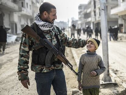 Un miliciano kurdo abraza a un niño en una calle de Kobane, este miércoles.