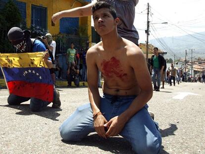 Un estudiante de rodillas, en la protesta en San Cristóbal.