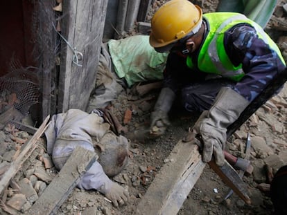 Equipos de rescate localizan a una víctima entre los escombros de un edificio en Katmandú.