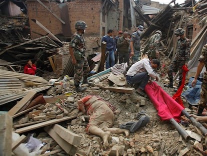 Treballadors de rescat al costat d'un cadàver a les runes d'un edifici a Bhaktapur.