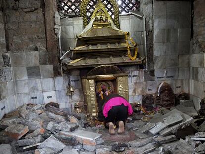Una mujer reza entre las ruinas de un templo hinduista en Katmandú.