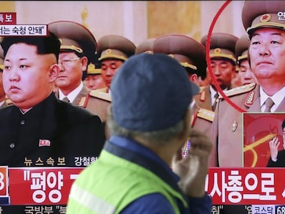 Homem observa TV que informa a morte do ministro de Defesa norte-coreano.