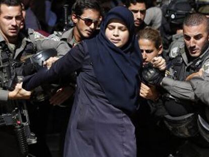 Las fuerzas de seguridad israelíes detienen a una mujer palestina.