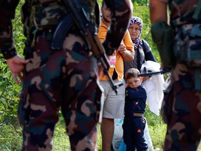 La policía frena a un familia de refugiados.
