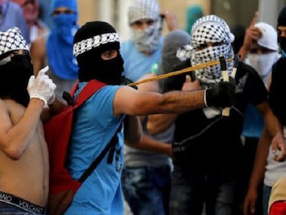 Un palestino lanza piedras a la policía israelí en Jerusalén Este.