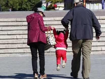 Dos abuelos sacan de paseo a su nieta en Pekín (China), el 30 de octubre de 2015. / ROLEX DELA PENA (EFE)