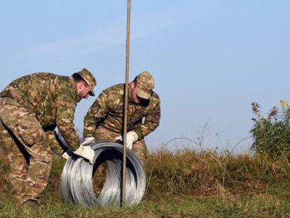 Soldats eslovens preparen la tanca fronterera.