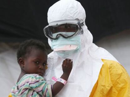 Un trabajador de Médicos Sin Fronteras sujeta un niño sospechoso de estar infectado por ébola en Liberia en octubre de 2014.