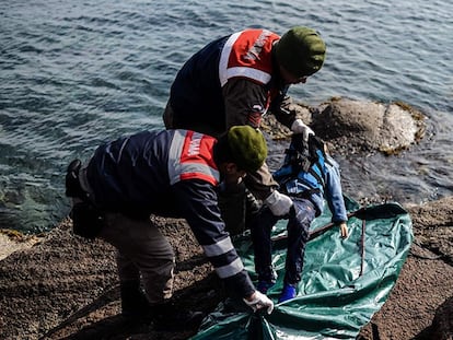 Policiais turcos colocam o corpo de uma criança morta por afogamento em uma bolsa na costa de Çanakkale.