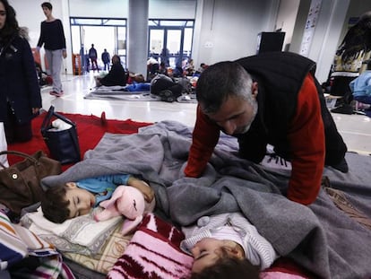 Migrantes descansam em edifício do porto vizinho a Atenas.