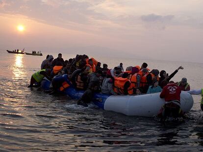 Un grupo de voluntarios ayuda a una embarcación neumática a llegar a la isla griega de Lesbos.