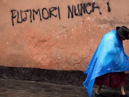Una mujer indígena camina junto a un graffiti en contra de Fujimori. Rodrigo Abd AP