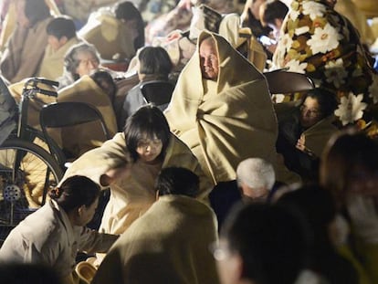 Un grupo de japoneses permanece a la intemperie, tras el terremoto.