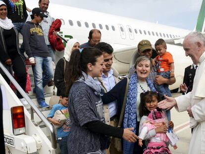 Los refugiados saludan al Pontífice a su llegada al aeropuerto de Roma.