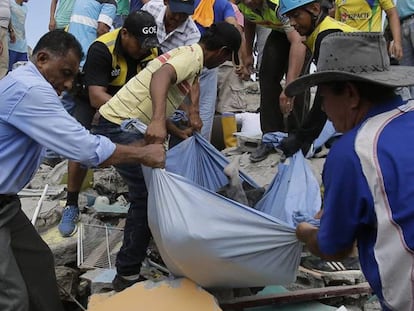 Voluntarios recuperan el cuerpo de una persona.