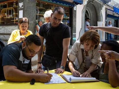 Pessoas coletam assinaturas pela realização de referendo.