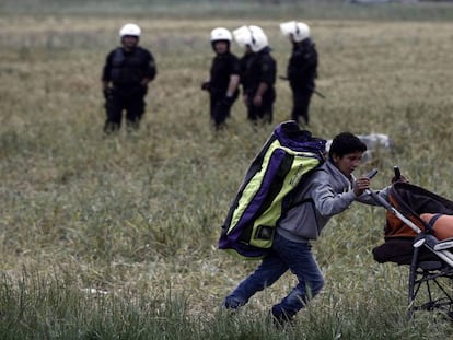 Un niño traslada sus pertenencias al evacuar Idomeni.