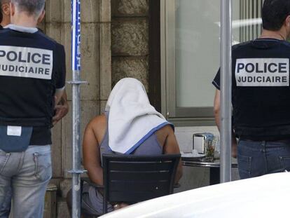 Uno de los detenidos, esposado y cubierto con una toalla.