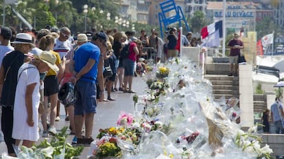 Multitud de personas se detienen ante las flores y velas depositadas en el paseo de los Ingleses, en recuerdo a las víctimas del atentado. EFE