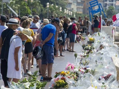Multitud de personas se detienen ante las flores y velas depositadas en el paseo de los Ingleses, en recuerdo a las víctimas del atentado. EFE
