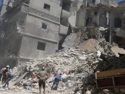 Civiles y 'cascos blancos' buscan supervivientes entre los escombros tras un bombardeo en Alepo.