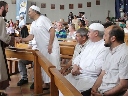 Un religioso católico saluda a fieles musulmanes que han acudido a la misa en una iglesia de Niza este domingo.