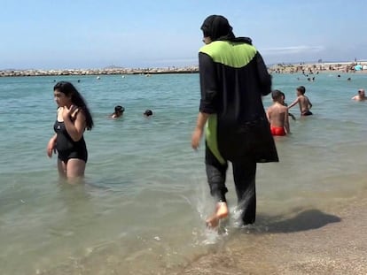 Una mujer viste un 'burkini' en una playa francesa.