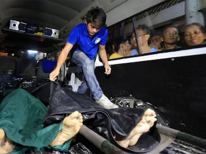 Residentes filipinos observan los restos de supuestos narcotraficantes abatidos en una operación contra drogas ilegales en Manila.