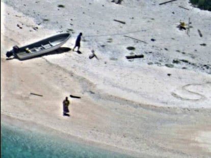 Uma foto do dia 25 de agosto que mostra os dois náufragos ao lado do SOS que desenharam na areia.