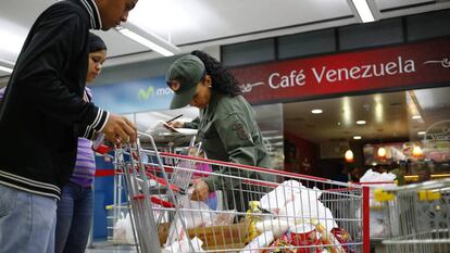 Uma militar revista um carrinho de compras em Caracas.