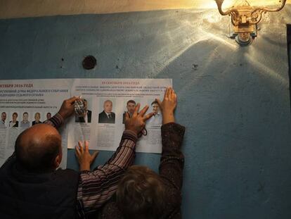 Funcionários de um colégio colocam panfletos eleitorais em Gusino, no oeste da Rússia.