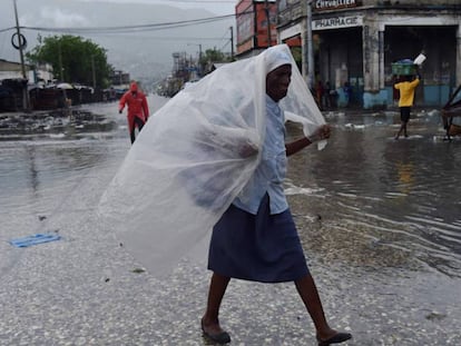 Mulher se protege da chuva na terça-feira em Porto Príncipe, no Haiti.