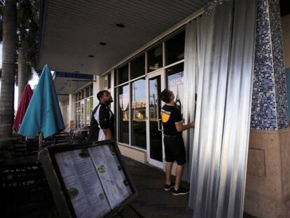 Empregados de um restaurante cobrem portas e janelas em Coral Springs (Flórida), nesta quarta-feira.