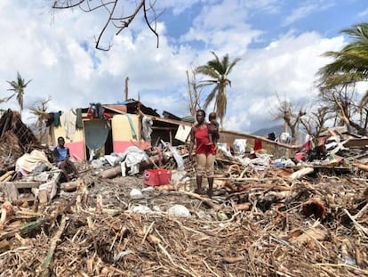 Uma mulher, na segunda-feira em frente à sua casa destruída no Haiti.