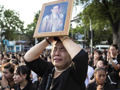 Una mujer que sostiene la fotografía del rey Bhumibol llora en una concentración en honor al rey fallecido, este viernes en el exterior del Gran Palacio de Bangkok. WASON WANICHAKORN AP