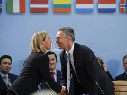 Federica Mogherini y Jens Stoltenberg se saludan en la reunión de ministros de Defensa.