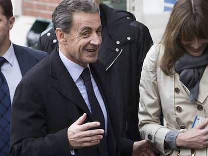 El expresidente francés Nicolás Sarkozy y su esposa, Carla Bruni-Sarkozy, salen de un despacho de voto durante la primera vuelta de las elecciones primarias.