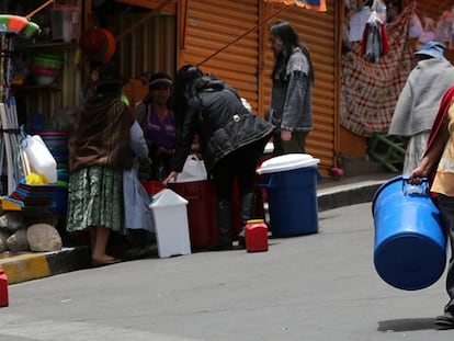 Una ciudadana de La Paz camina con un recipiente para recibir agua.