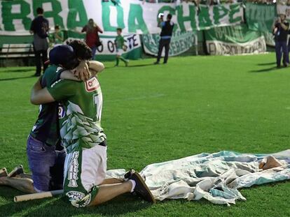 Two fans hug during a tribute to Chapecoense