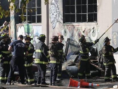 Un equipo de bomberos revisa el acceso durante las labores de rescate en la nave siniestrada en Oakland.