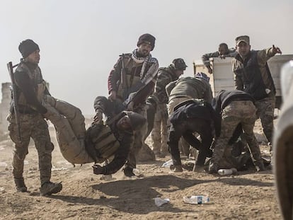Soldados iraquíes transportan a un herido cerca de Mosul.