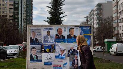 Una mujer pasa delante de varios carteles electorales, el viernes en Bucarest.