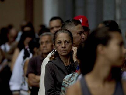 Una fila de persona espera para poder cambiar los billetes de 100 bolívares en el Banco de la República, en Caracas. Fernando Llano AP