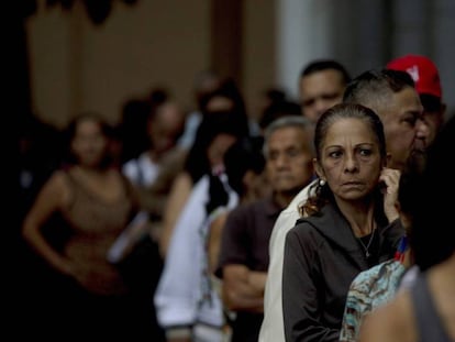 Una fila de persona espera para poder cambiar los billetes de 100 bolívares en el Banco de la República, en Caracas. Fernando Llano AP