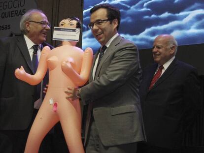 Fotografía del 13 de diciembre de 2016 del ministro de Economía de Chile, Luis Felipe Céspedes recibiendo la muñeca.