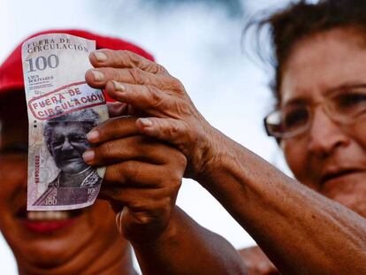 Una seguidora de Maduro sostiene un billete de 100 bolívares.
